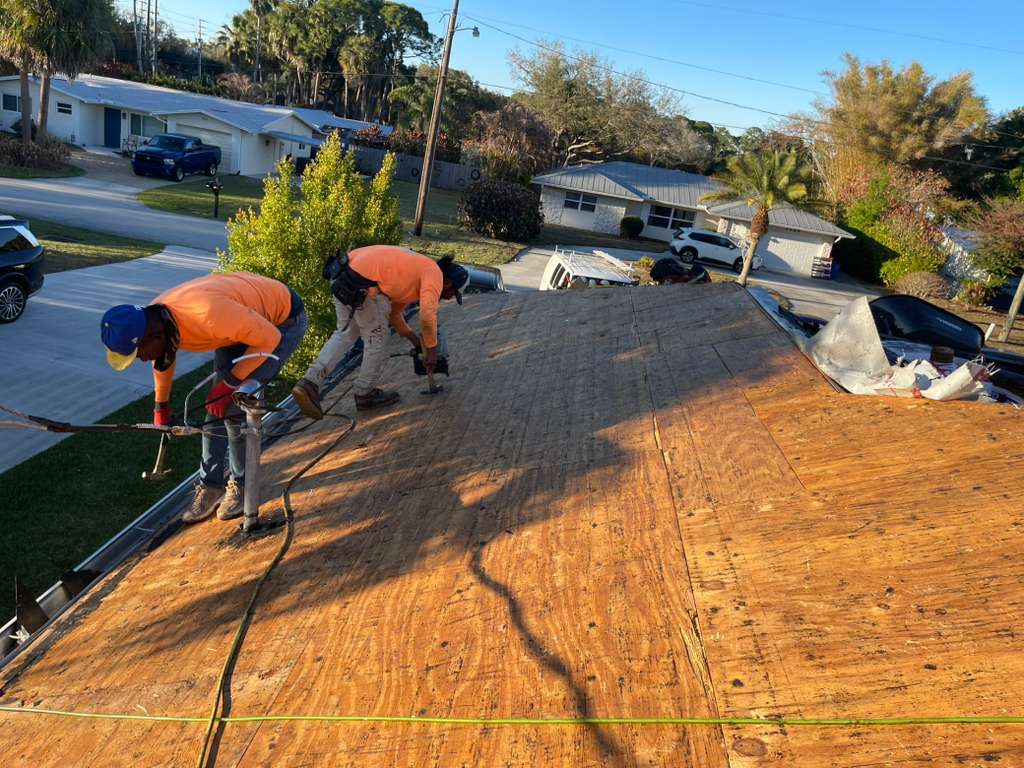 Worker on shingle roof in progress in South Florida